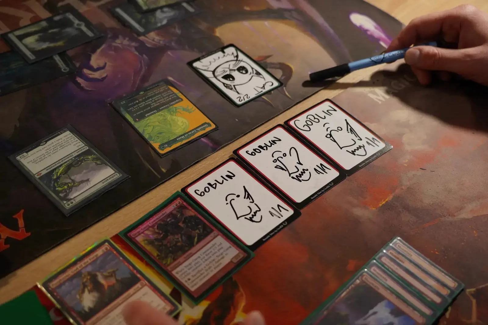 Three reusable tokens drawn as goblins lined up on the battlefield during a Magic game
