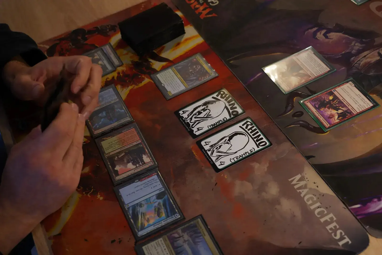 Reusable tokens drawn as 4/4 rhinos with trample, in play next to real Magic cards