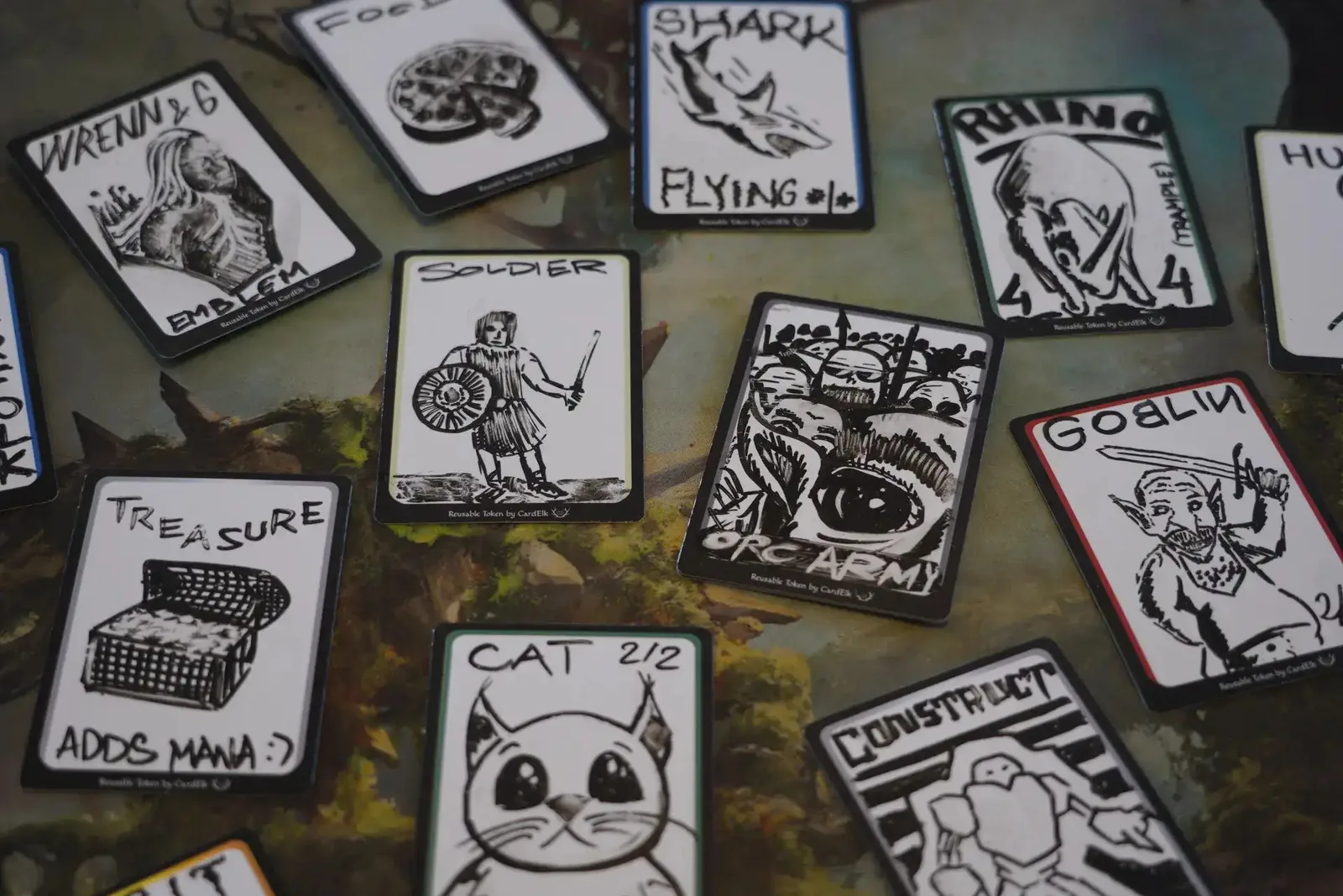 Reusable tokens drawn as shark, soldier, cat and construct on a mossy playmat